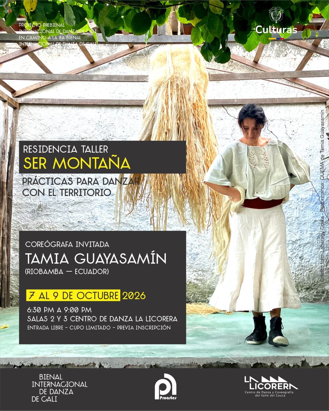 Afiche promocional de la residencia taller 'Ser montaña: prácticas para danzar con el territorio', dirigida por la coreógrafa invitada Tamia Guayasamín. En la fotografía principal aparece Tamia de cuerpo entero, vistiendo blusa y falda amplias de color blanco con un cinturón rojo, mirando hacia abajo en actitud contemplativa. Detrás de ella cuelga un gran atado de fibras naturales secas bajo una estructura rústica al aire libre. El cartel incluye los textos con la información del evento: del 7 al 9 de octubre de 2026, de 6:30 p.m. a 9:00 p.m. en el Centro de Danza La Licorera, junto con los logotipos de la Bienal Internacional de Danza de Cali, Proartes y el Ministerio de las Culturas.